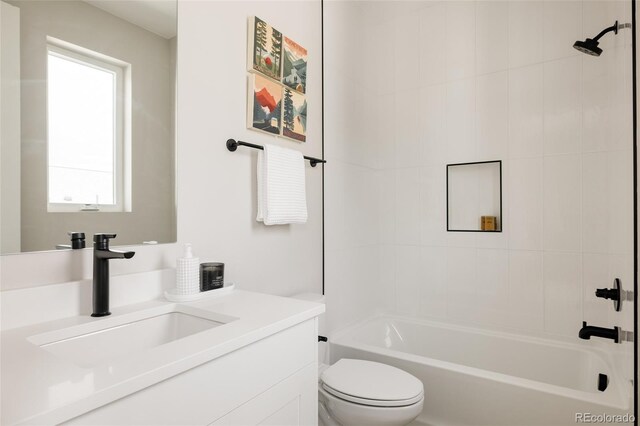 bathroom featuring toilet, vanity, and shower / washtub combination