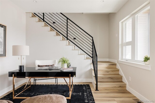 stairs with wood finished floors and baseboards
