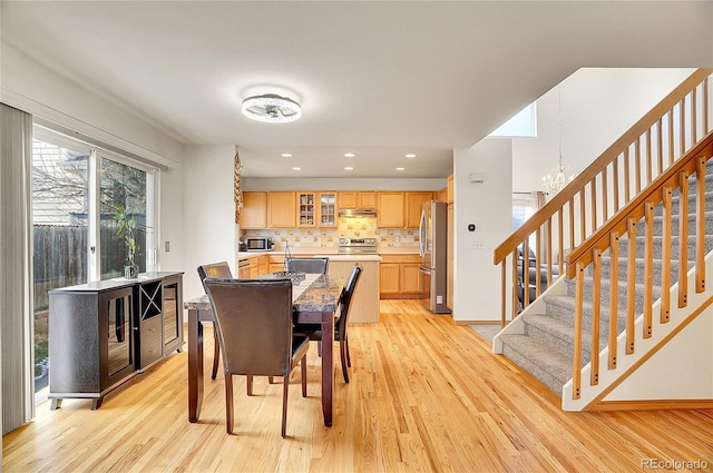 dining space featuring light hardwood / wood-style flooring, beverage cooler, and an inviting chandelier