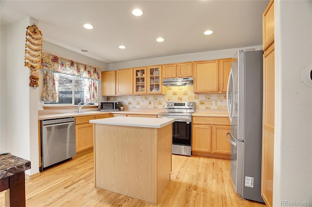 kitchen featuring appliances with stainless steel finishes, a center island, light hardwood / wood-style flooring, and light brown cabinetry