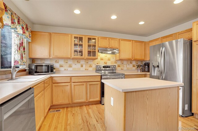 kitchen featuring a kitchen island, sink, stainless steel appliances, and light brown cabinets