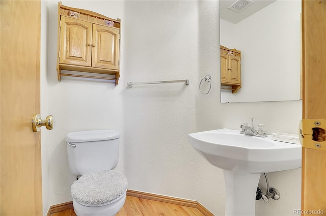 bathroom featuring hardwood / wood-style floors, toilet, and sink