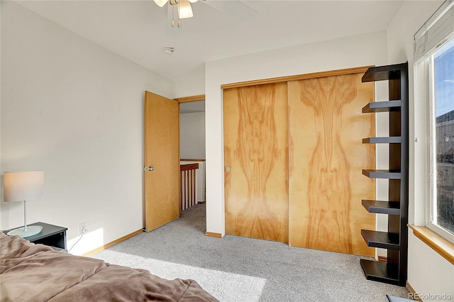 unfurnished bedroom with ceiling fan, light carpet, and a closet