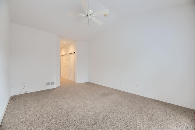 carpeted empty room with ceiling fan and lofted ceiling