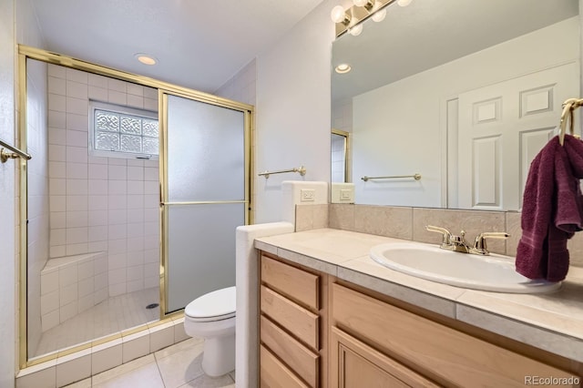 bathroom featuring vanity, toilet, a shower with door, and tile patterned flooring