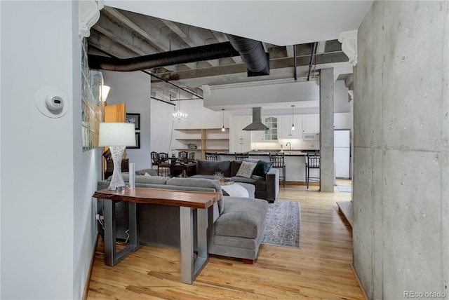 living room with light wood-type flooring and a chandelier