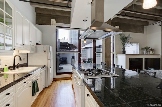 kitchen featuring range, a sink, island exhaust hood, glass insert cabinets, and tile countertops