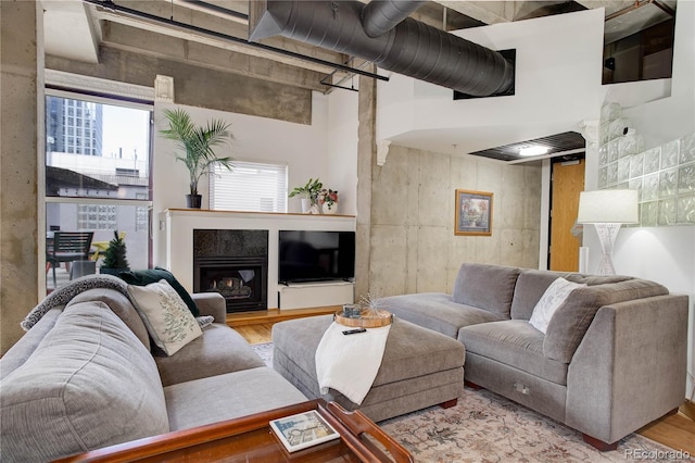 living room with a glass covered fireplace and wood finished floors
