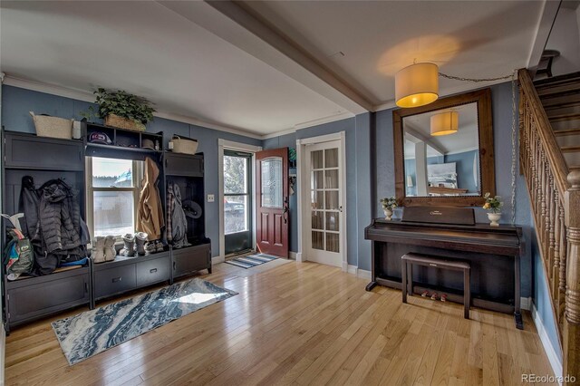 interior space featuring crown molding, wood finished floors, baseboards, and stairs