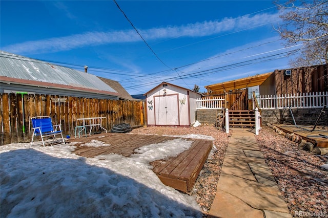 view of yard featuring a storage shed, a fenced backyard, and an outbuilding