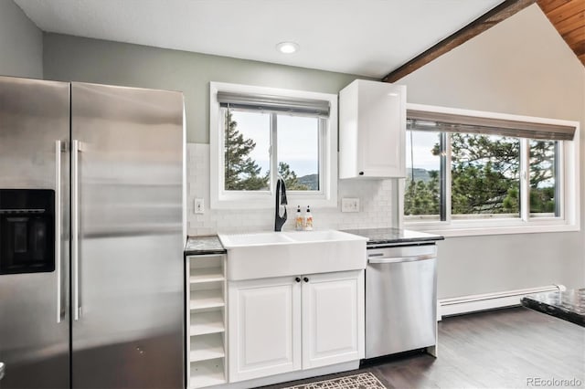 9189 Fallen Rock Rd, Conifer, CO 80433 - kitchen with stainless steel appliances, baseboard heating, white cabinetry, dark wood-style floors, and tasteful backsplash