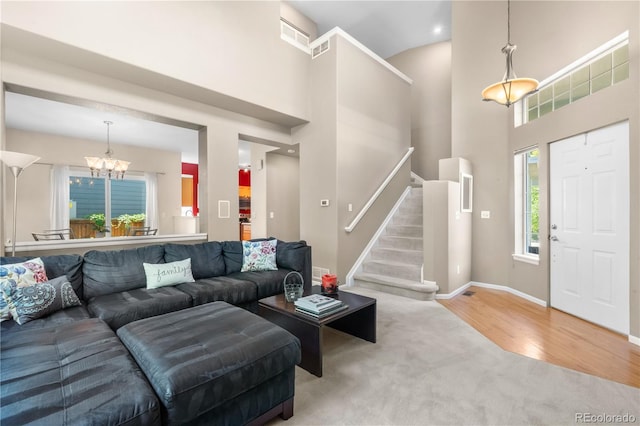 10262 Spotted Owl Ave, Highlands Ranch, CO 80129 - carpeted living room featuring a chandelier, stairway, a high ceiling, and wood finished floors