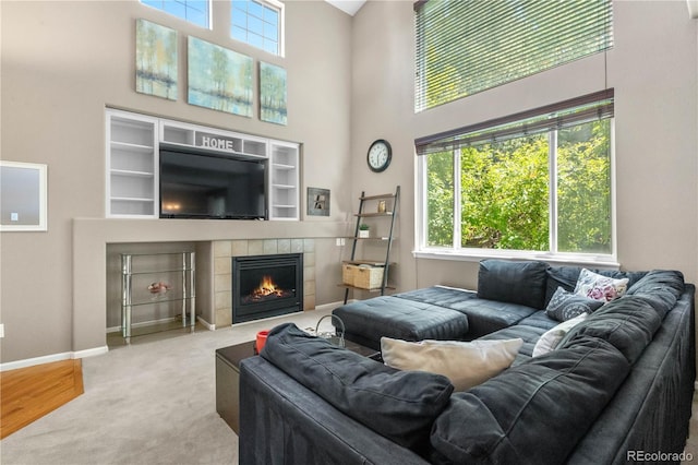 10262 Spotted Owl Ave, Highlands Ranch, CO 80129 - living room featuring a towering ceiling, a fireplace, and carpet flooring