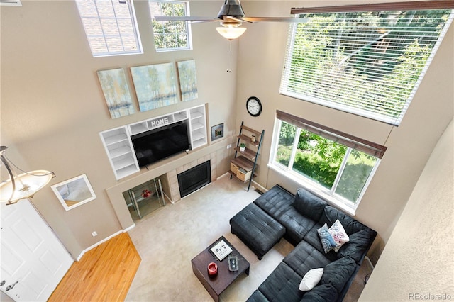 10262 Spotted Owl Ave, Highlands Ranch, CO 80129 - living room featuring a high ceiling, a tile fireplace, a ceiling fan, and built in shelves