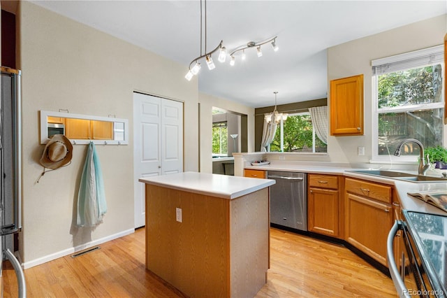 10262 Spotted Owl Ave, Highlands Ranch, CO 80129 - kitchen featuring dishwasher, stove, light wood-style flooring, a center island, and a chandelier