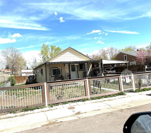 view of front of house featuring covered porch and a fenced front yard