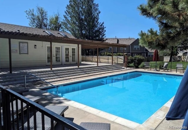 pool with fence, a patio, and french doors