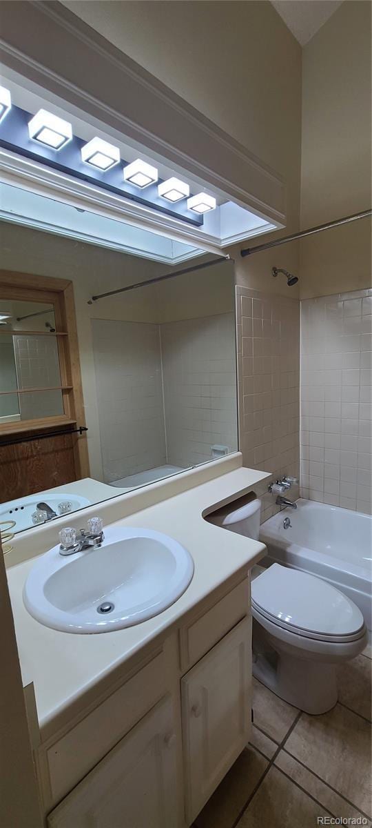 full bathroom featuring tiled shower / bath combo, vanity, tile patterned flooring, and toilet