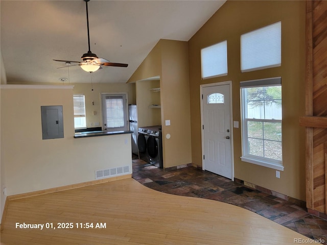 entryway featuring ceiling fan, high vaulted ceiling, electric panel, wood-type flooring, and washer and dryer