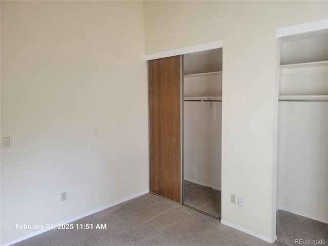 unfurnished bedroom with multiple closets and carpet flooring