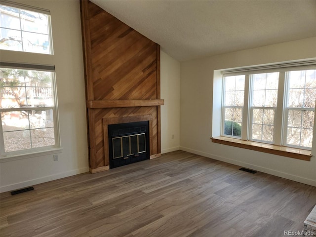 unfurnished living room featuring a wealth of natural light, a fireplace, and visible vents