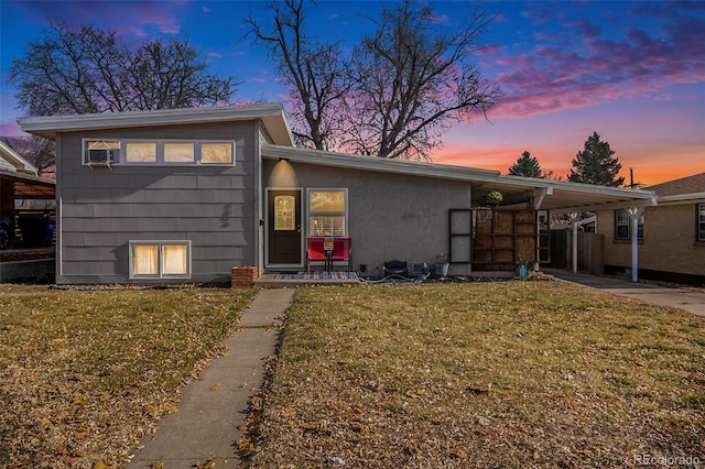 view of front of property with a carport and a yard