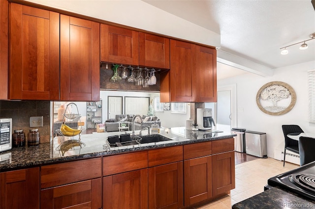 1654 S Perry St, Denver, CO 80219 - kitchen with decorative backsplash, dark stone countertops, brown cabinets, and beamed ceiling