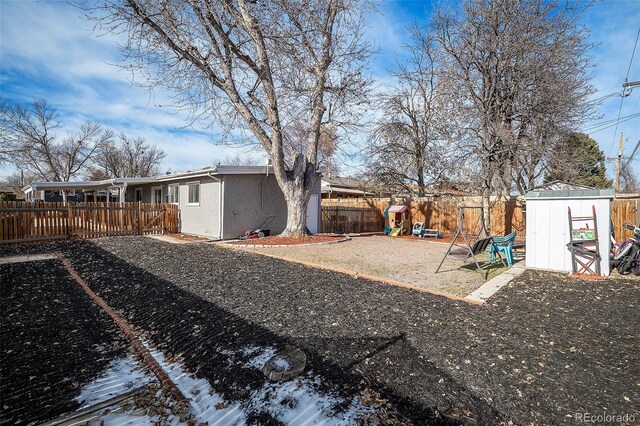 1654 S Perry St, Denver, CO 80219 - fenced backyard with a playground and a shed