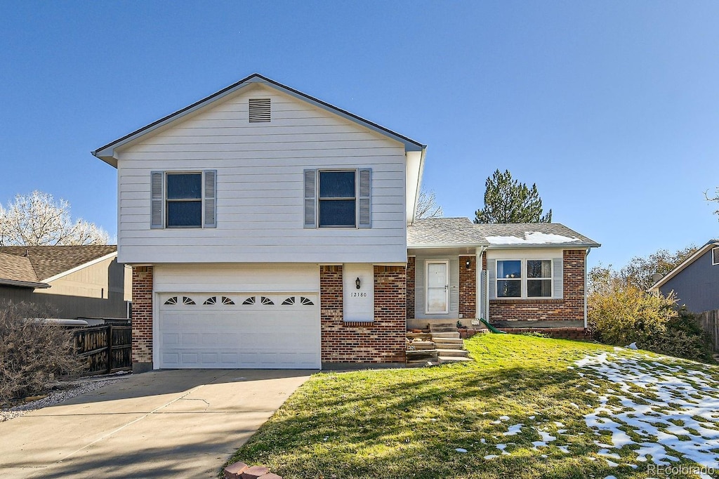 tri-level home with a garage and a front lawn