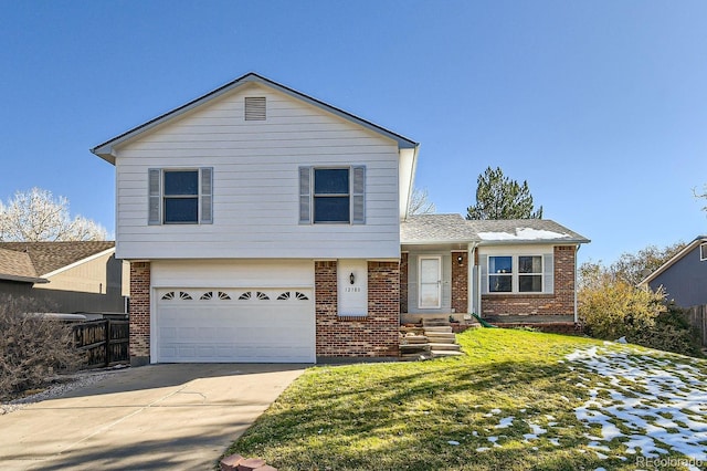 tri-level home with a garage and a front lawn