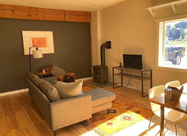 living room featuring a wood stove, a wealth of natural light, and hardwood / wood-style floors