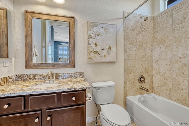 bathroom featuring a healthy amount of sunlight, a textured wall, vanity, and toilet