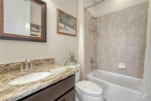 full bath with shower / bath combination, a textured wall, vanity, and toilet