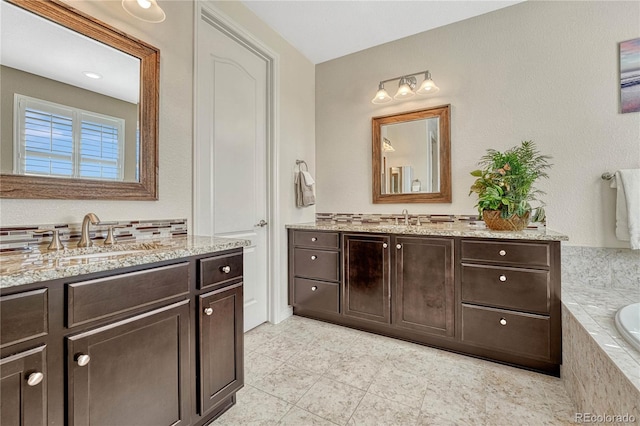 bathroom featuring two vanities, a sink, and a bathtub