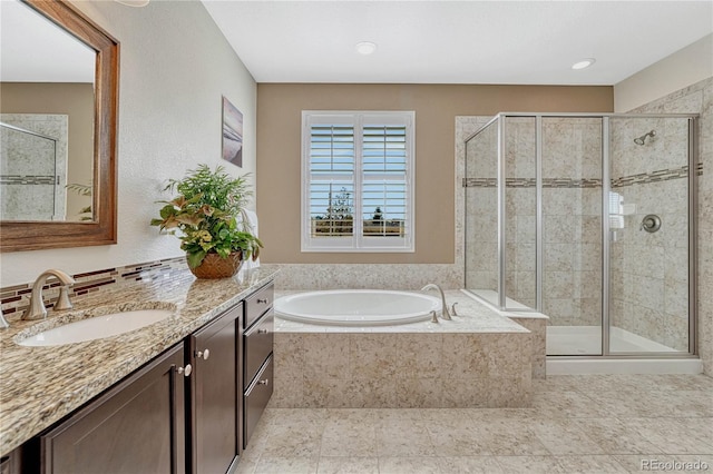 bathroom with a stall shower, tile patterned floors, a garden tub, and vanity