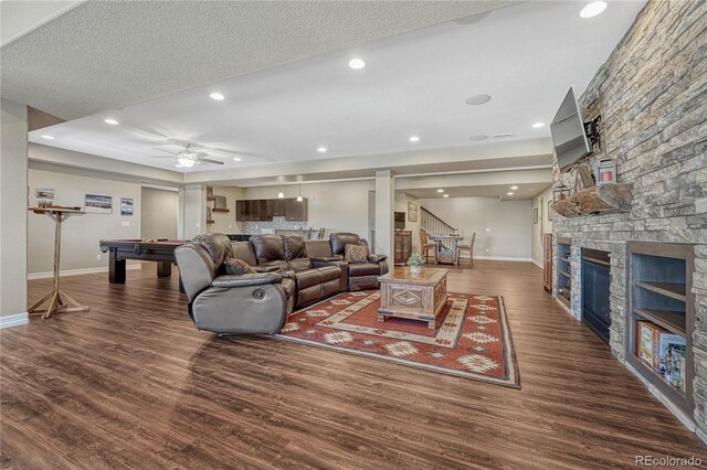 living area with stairs, a fireplace, wood finished floors, and pool table