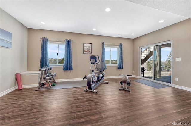 exercise area featuring a textured ceiling, recessed lighting, wood finished floors, and baseboards