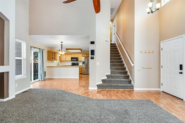12535 Forest View St, Broomfield, CO 80020 - entryway featuring a high ceiling, light wood finished floors, a ceiling fan, and stairs