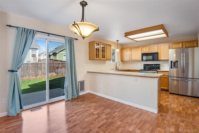 12535 Forest View St, Broomfield, CO 80020 - kitchen with visible vents, glass insert cabinets, a sink, light wood finished floors, and stainless steel appliances