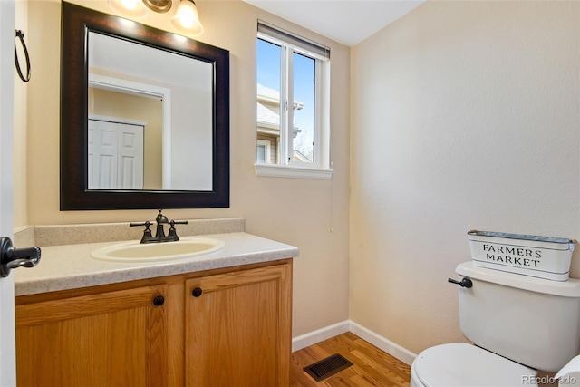 12535 Forest View St, Broomfield, CO 80020 - bathroom featuring visible vents, wood finished floors, baseboards, vanity, and toilet