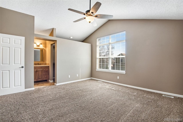 12535 Forest View St, Broomfield, CO 80020 - unfurnished bedroom with ensuite bath, carpet floors, a textured ceiling, baseboards, and lofted ceiling