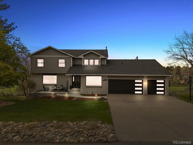view of front of home with roof with shingles, a yard, concrete driveway, an attached garage, and stucco siding