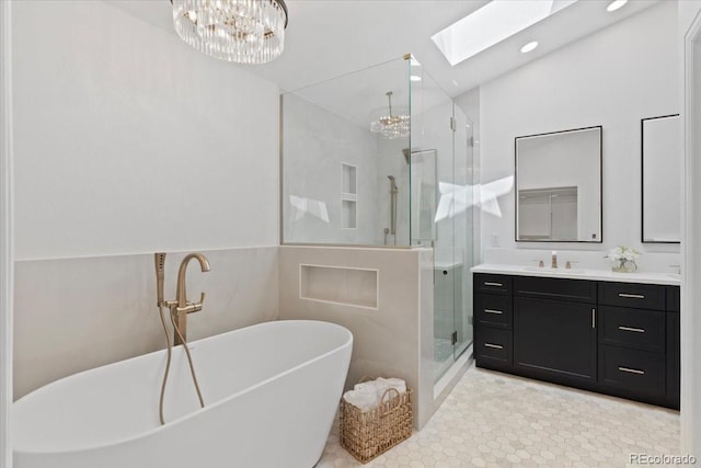 bathroom featuring vanity, recessed lighting, a freestanding bath, a shower stall, and a skylight