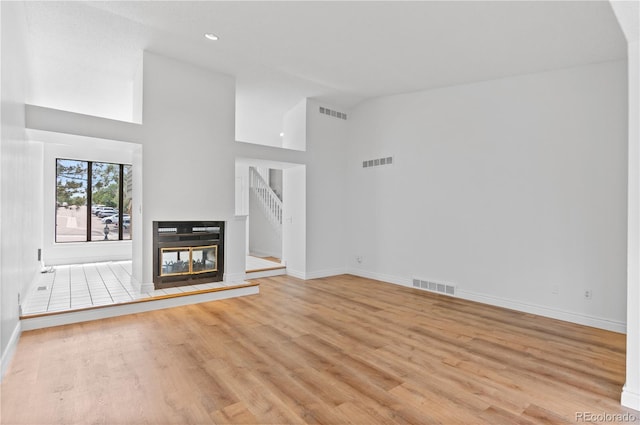 3871 E Euclid Ave, Centennial, CO 80121 - unfurnished living room with high vaulted ceiling, light wood finished floors, recessed lighting, and a multi sided fireplace