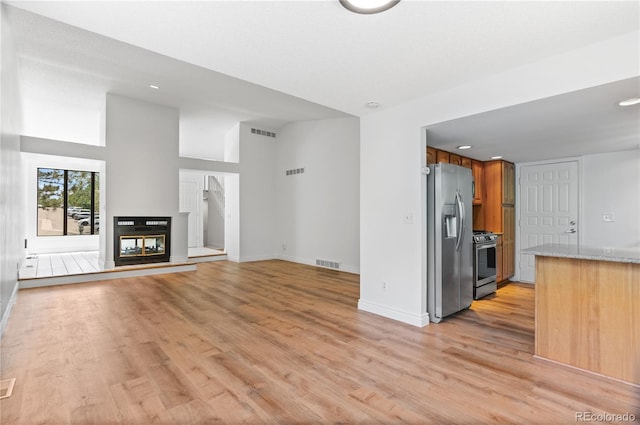 3871 E Euclid Ave, Centennial, CO 80121 - unfurnished living room featuring light wood finished floors, recessed lighting, and a multi sided fireplace