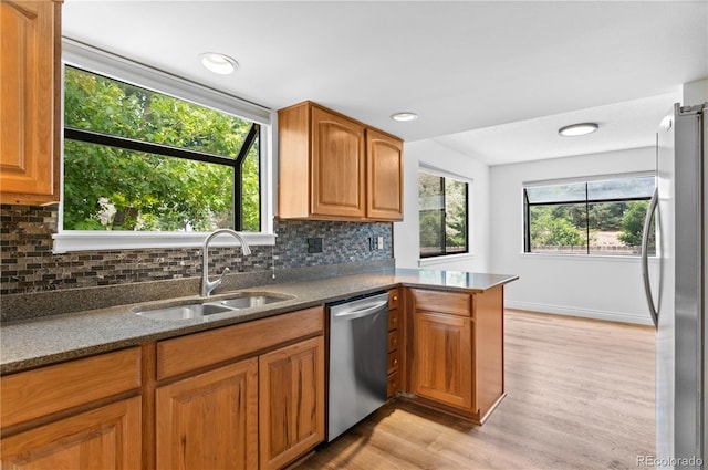 3871 E Euclid Ave, Centennial, CO 80121 - kitchen with appliances with stainless steel finishes, light wood-type flooring, decorative backsplash, brown cabinets, and dark stone counters