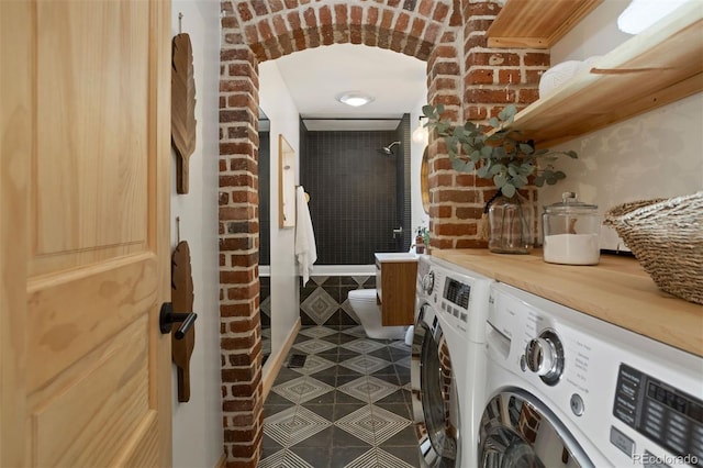 interior space featuring laundry area, brick wall, separate washer and dryer, and tile patterned floors