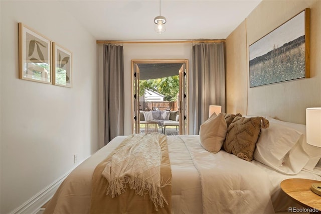 bedroom featuring access to exterior and baseboards