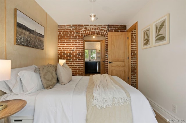 bedroom with brick wall and baseboards