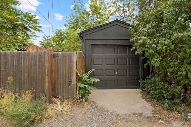 detached garage with driveway and fence